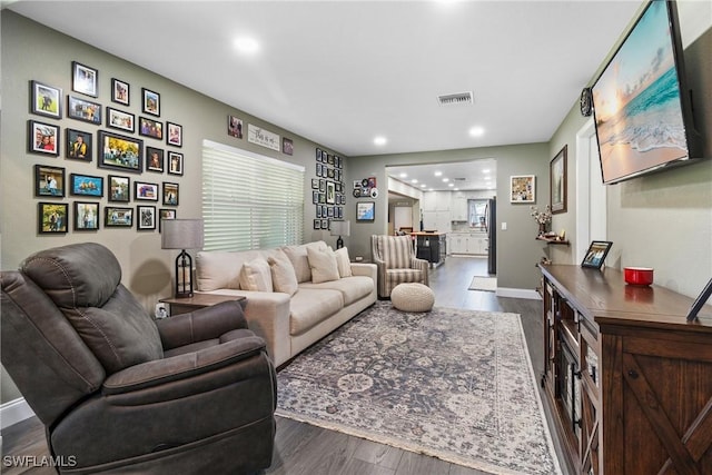 living room featuring dark wood-type flooring, recessed lighting, visible vents, and baseboards