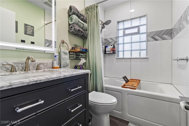 bathroom with shower / bath combo with shower curtain, toilet, and vanity