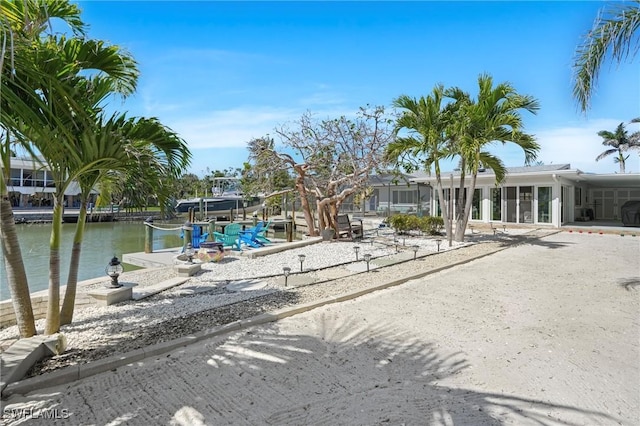 exterior space with a water view, boat lift, and a dock