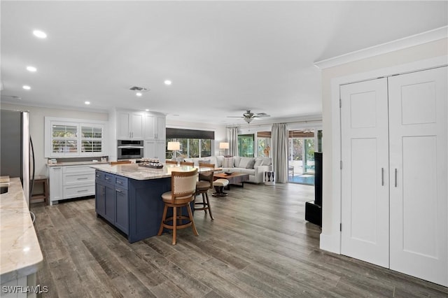 kitchen featuring freestanding refrigerator, visible vents, crown molding, and white cabinetry