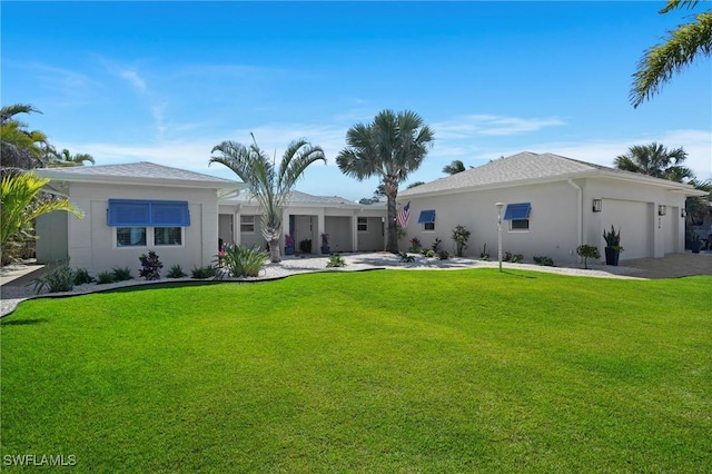 back of house featuring a garage, a lawn, and stucco siding