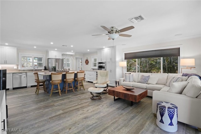 living area featuring light wood-type flooring, visible vents, a ceiling fan, and recessed lighting