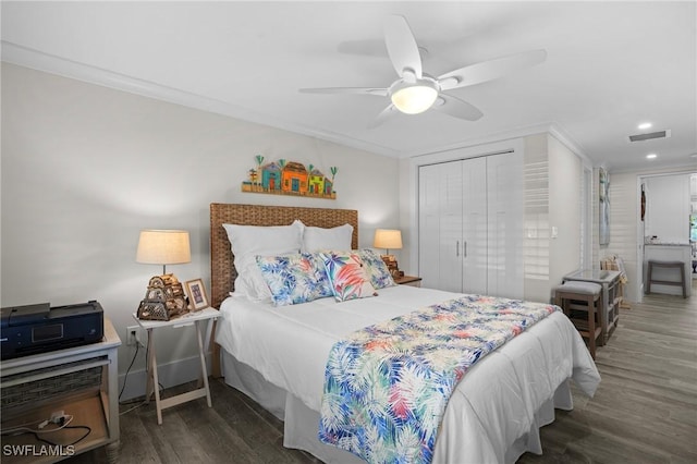 bedroom featuring crown molding, a closet, visible vents, and wood finished floors