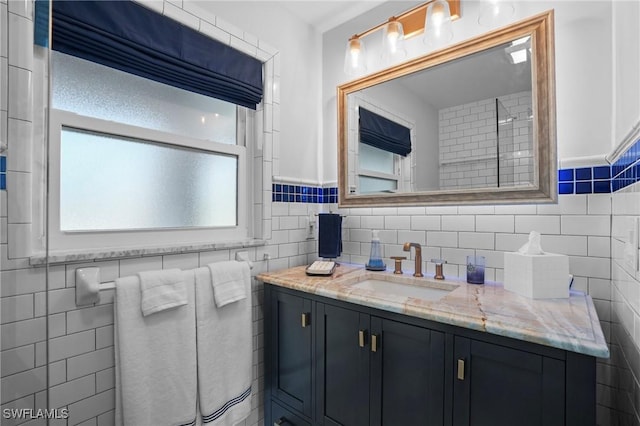 bathroom featuring vanity and tile walls