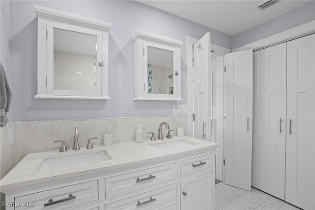 bathroom featuring double vanity, a sink, and visible vents