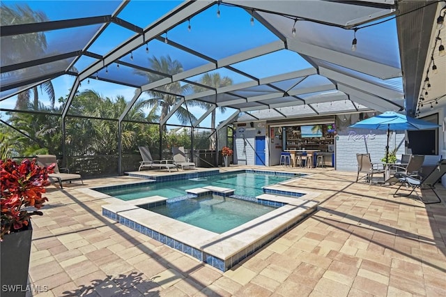 view of pool featuring glass enclosure, a patio area, and a pool with connected hot tub