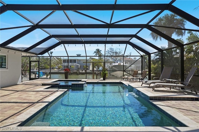 view of pool featuring a lanai, a pool with connected hot tub, and a patio