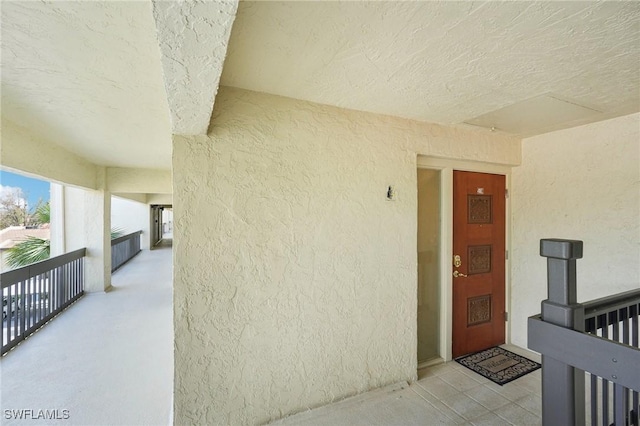 property entrance featuring a balcony and stucco siding