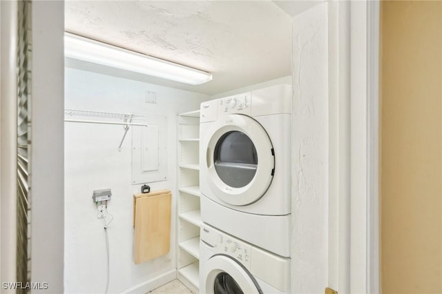 clothes washing area with stacked washer / dryer and laundry area