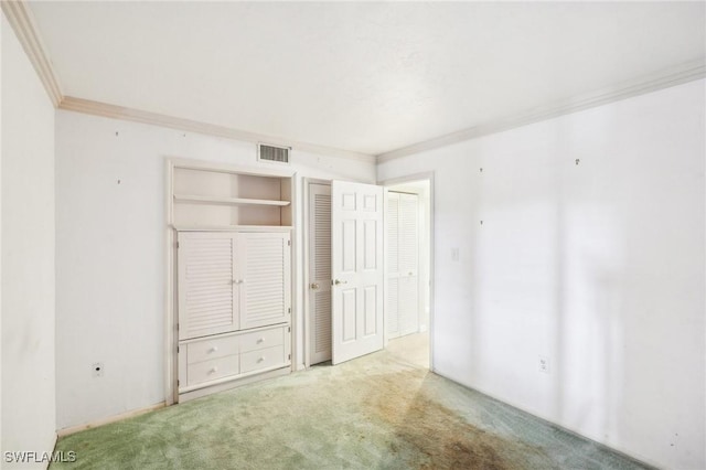 unfurnished bedroom with ornamental molding, visible vents, and carpet flooring