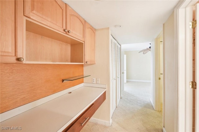 hallway featuring baseboards and light floors