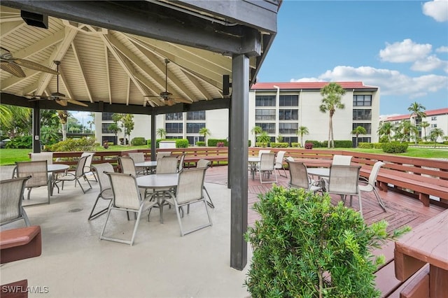 view of patio featuring a ceiling fan, outdoor dining space, a deck, and a gazebo