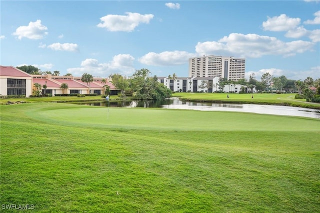 view of property's community featuring view of golf course, a water view, and a yard