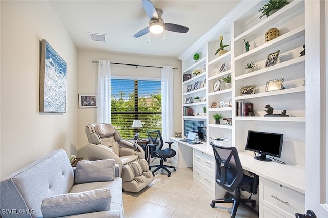 home office with visible vents, built in shelves, light tile patterned floors, built in desk, and a ceiling fan