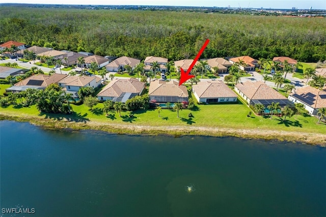 aerial view featuring a residential view, a wooded view, and a water view