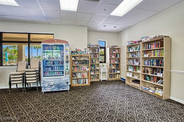 misc room featuring baseboards, a paneled ceiling, and carpet