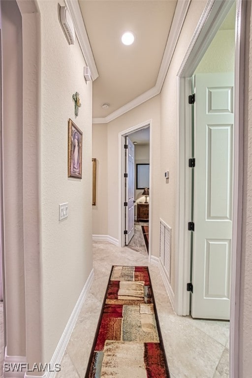 hall with crown molding, baseboards, and visible vents