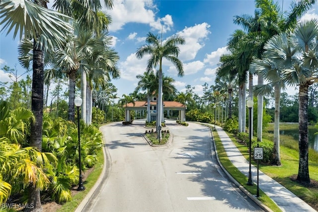 view of street featuring sidewalks, curbs, traffic signs, and street lighting