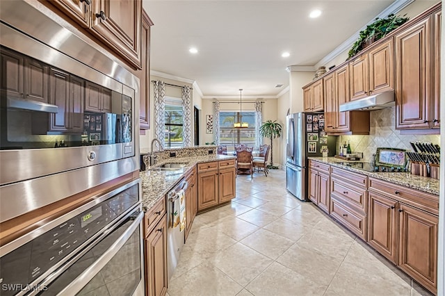 kitchen with tasteful backsplash, under cabinet range hood, ornamental molding, appliances with stainless steel finishes, and a sink