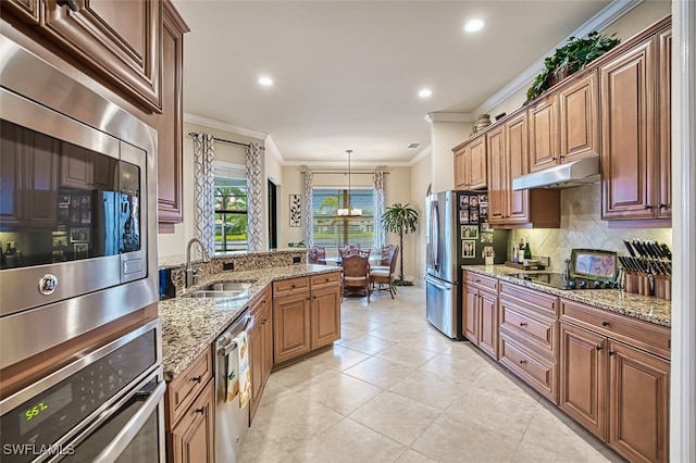 kitchen featuring ornamental molding, decorative backsplash, a sink, under cabinet range hood, and appliances with stainless steel finishes