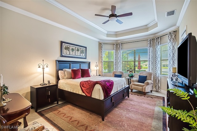 tiled bedroom with visible vents, crown molding, ceiling fan, baseboards, and a tray ceiling