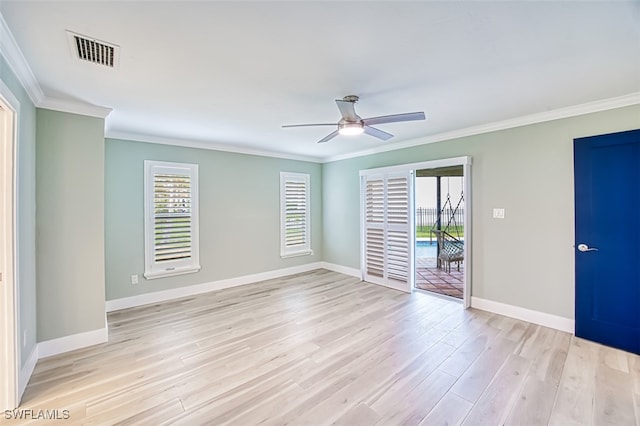 spare room with ornamental molding, light wood-style flooring, visible vents, and baseboards