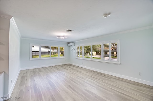 unfurnished room featuring baseboards, visible vents, wood finished floors, a wall mounted air conditioner, and crown molding