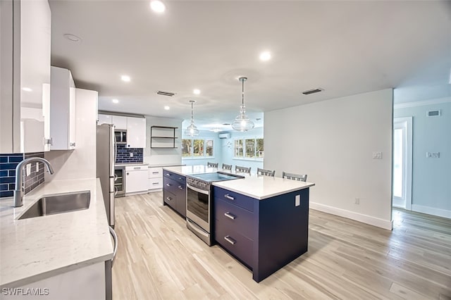 kitchen with tasteful backsplash, visible vents, stainless steel appliances, white cabinetry, and a sink