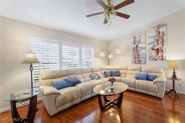 living area featuring lofted ceiling, baseboards, a ceiling fan, and wood finished floors