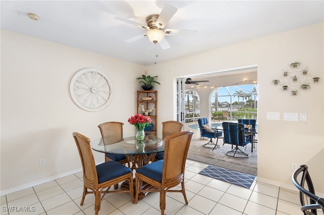 dining space featuring a sunroom, baseboards, a ceiling fan, and light tile patterned flooring