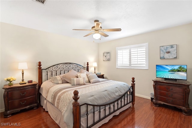 bedroom with ceiling fan, wood finished floors, and baseboards