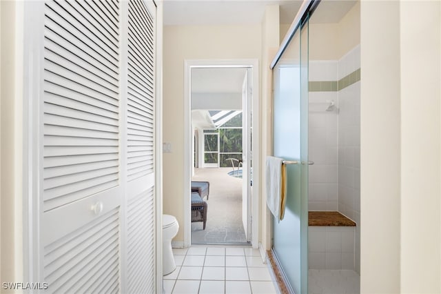 bathroom featuring a closet, tile patterned flooring, a shower stall, and toilet