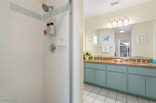 full bathroom featuring tiled shower, a sink, visible vents, and double vanity