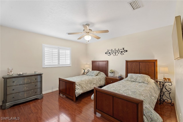 bedroom with baseboards, ceiling fan, visible vents, and wood finished floors