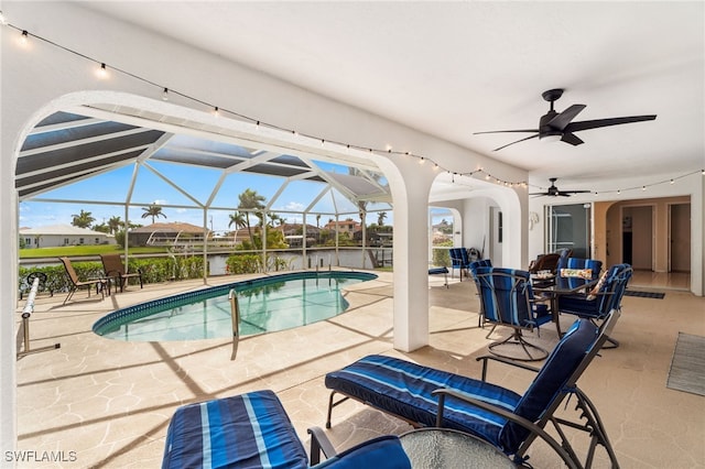 outdoor pool featuring ceiling fan, a patio, and glass enclosure