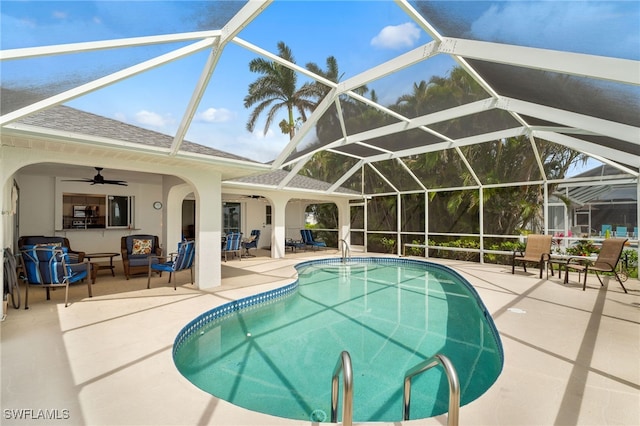 outdoor pool with a lanai, outdoor lounge area, a ceiling fan, and a patio