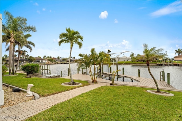 dock area with a water view, boat lift, and a yard