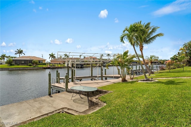 view of dock with a water view, a yard, boat lift, and fence