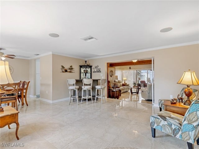 living area with crown molding, a ceiling fan, baseboards, and visible vents