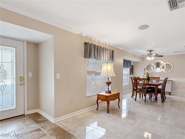 dining space featuring visible vents, a ceiling fan, baseboards, and ornamental molding