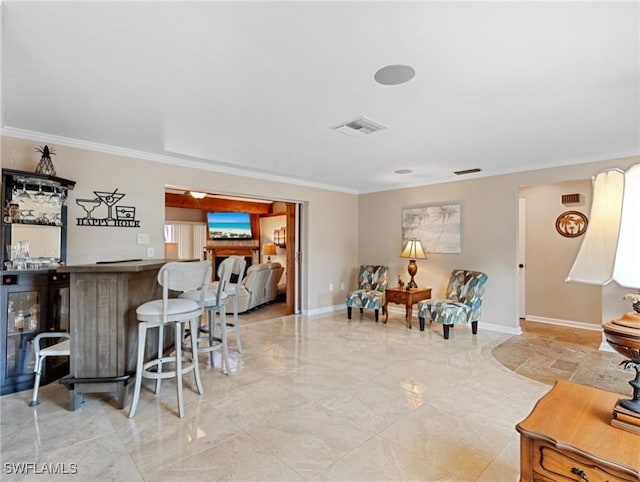 living area featuring crown molding, a dry bar, visible vents, and baseboards