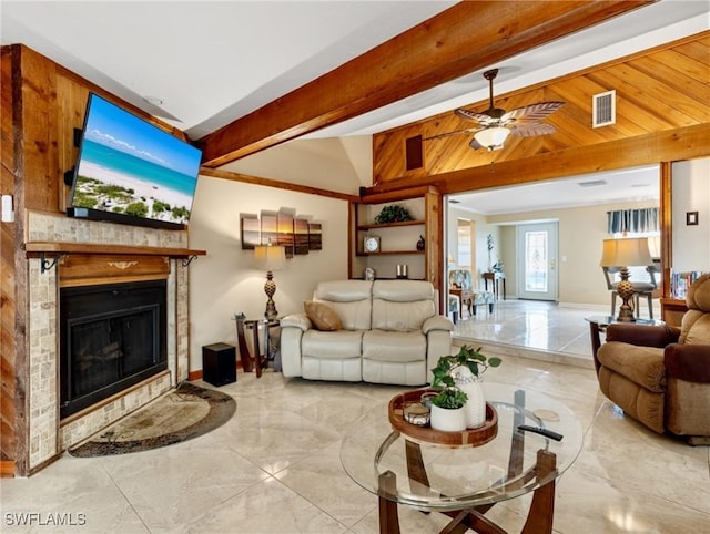 living room with visible vents, lofted ceiling with beams, a glass covered fireplace, marble finish floor, and a ceiling fan