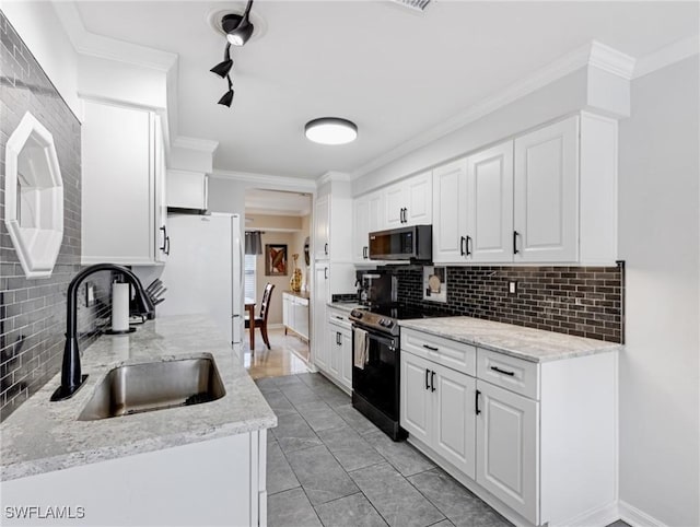 kitchen with freestanding refrigerator, a sink, crown molding, black range with electric stovetop, and stainless steel microwave