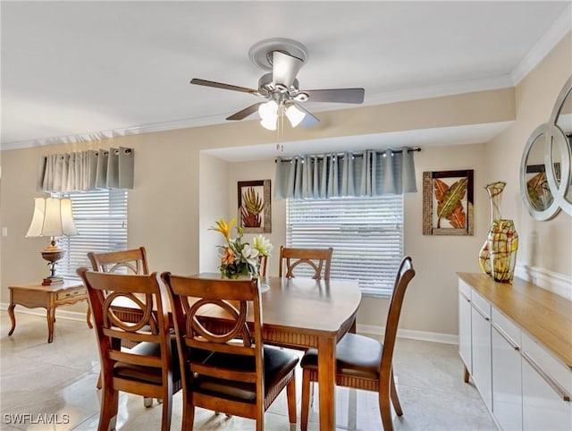 dining area featuring light tile patterned floors, baseboards, a ceiling fan, and crown molding