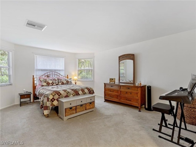 bedroom featuring visible vents, multiple windows, and light colored carpet