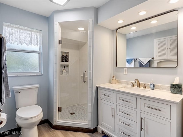 full bath with toilet, a stall shower, wood finished floors, recessed lighting, and vanity