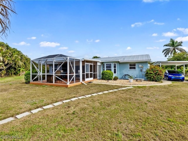 view of front of home featuring metal roof, a carport, a lanai, and a front yard