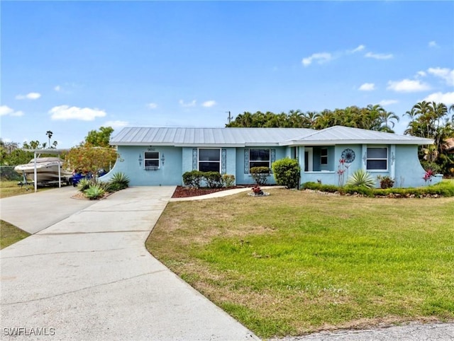 single story home with stucco siding, driveway, metal roof, and a front lawn