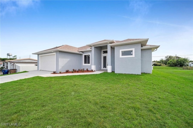 prairie-style home with a garage, a front lawn, concrete driveway, and stucco siding