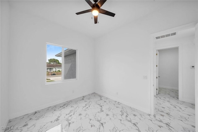 empty room with marble finish floor, visible vents, and baseboards